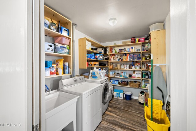 clothes washing area featuring washing machine and clothes dryer, dark hardwood / wood-style floors, and sink