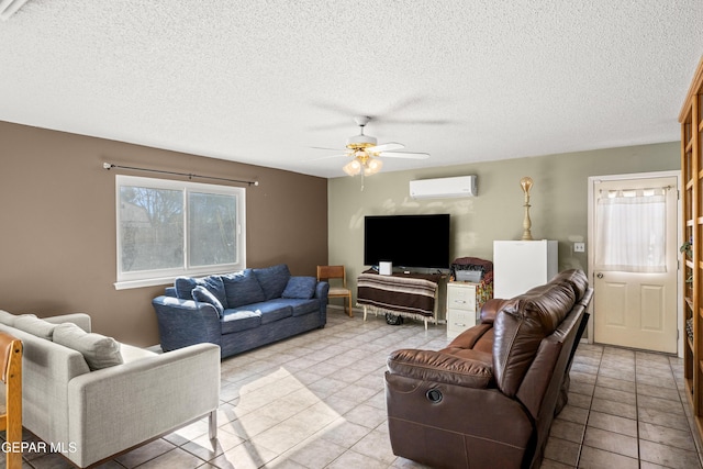 living room with a wall mounted air conditioner, a textured ceiling, ceiling fan, and light tile patterned flooring