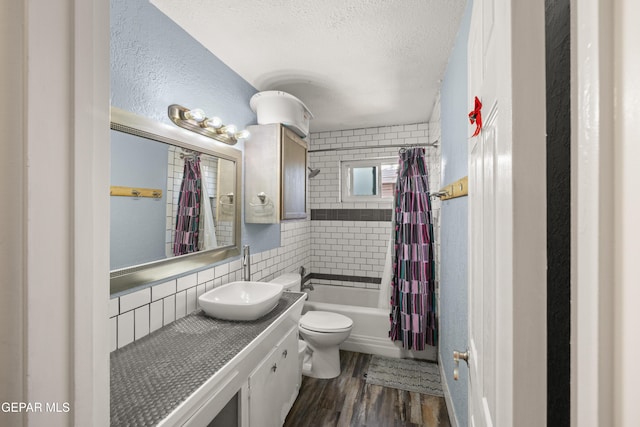 full bathroom with shower / tub combo, vanity, a textured ceiling, hardwood / wood-style floors, and toilet