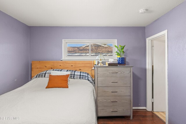 bedroom with dark wood-type flooring