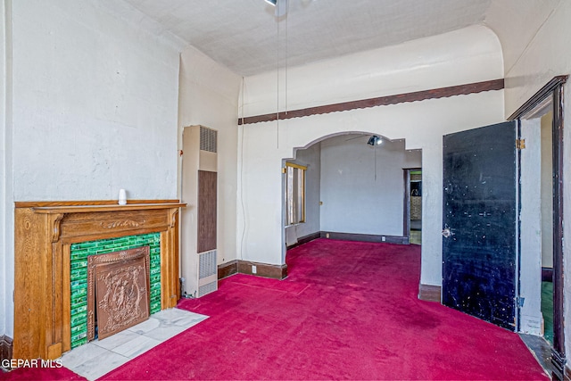 carpeted living room featuring a tiled fireplace