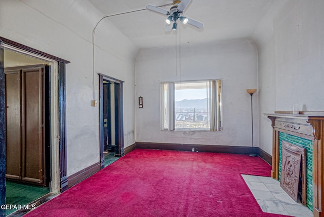 carpeted living room with ceiling fan and vaulted ceiling