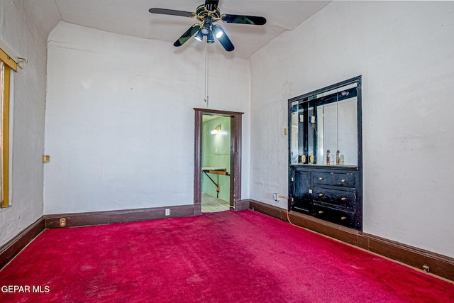 unfurnished bedroom featuring carpet floors, vaulted ceiling, and ceiling fan