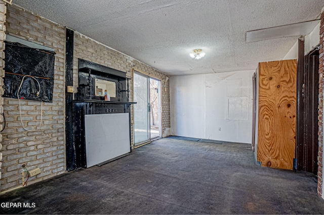 interior space with a textured ceiling and brick wall