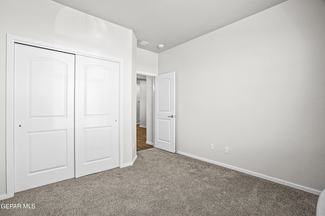 unfurnished bedroom featuring carpet and a closet