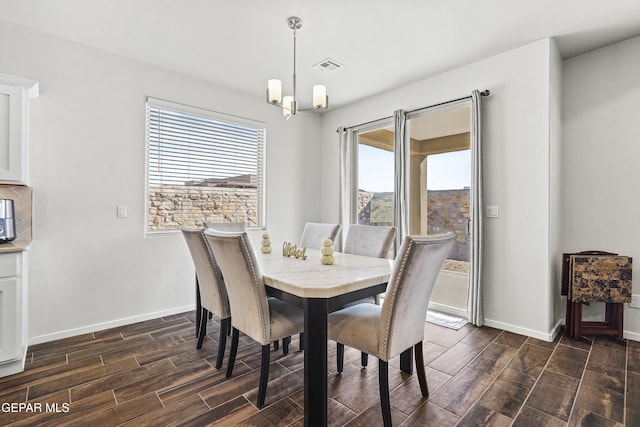 dining room with a chandelier, a wealth of natural light, and dark wood-type flooring