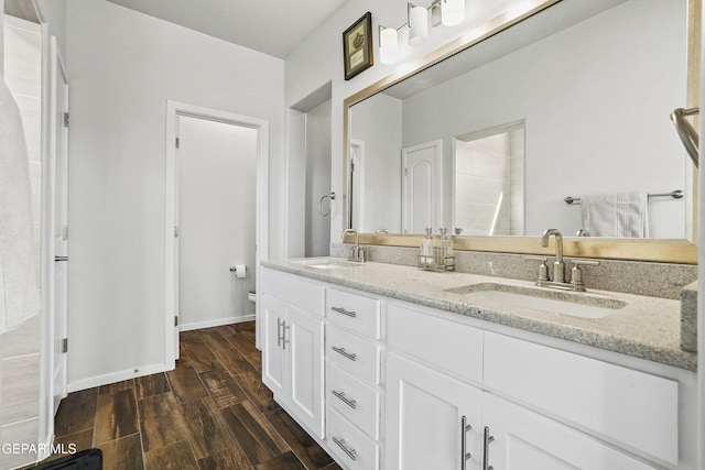 bathroom with toilet, vanity, and hardwood / wood-style flooring