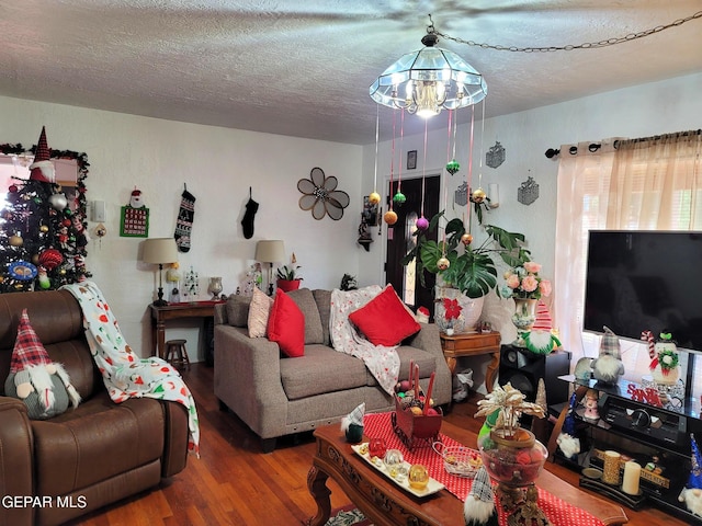 living room with a notable chandelier, wood-type flooring, and a textured ceiling