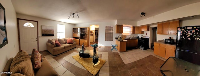 living room featuring sink and light tile patterned flooring