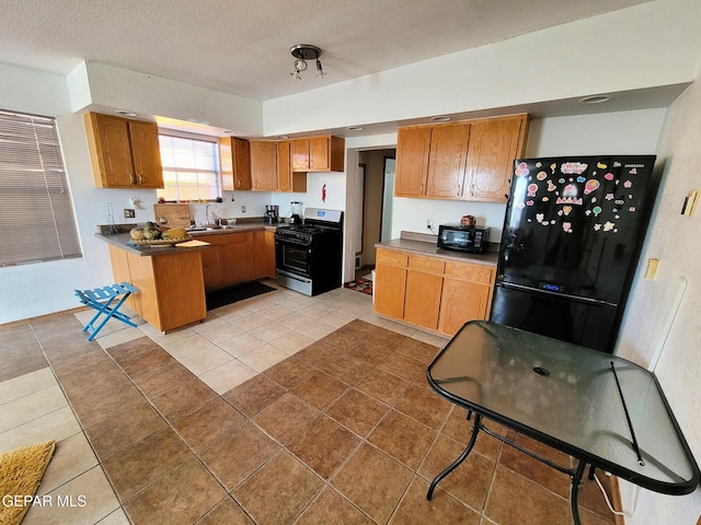 kitchen with sink, light tile patterned flooring, black appliances, and a textured ceiling