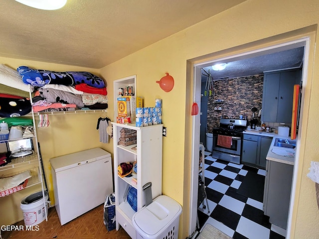 laundry room with a textured ceiling and sink