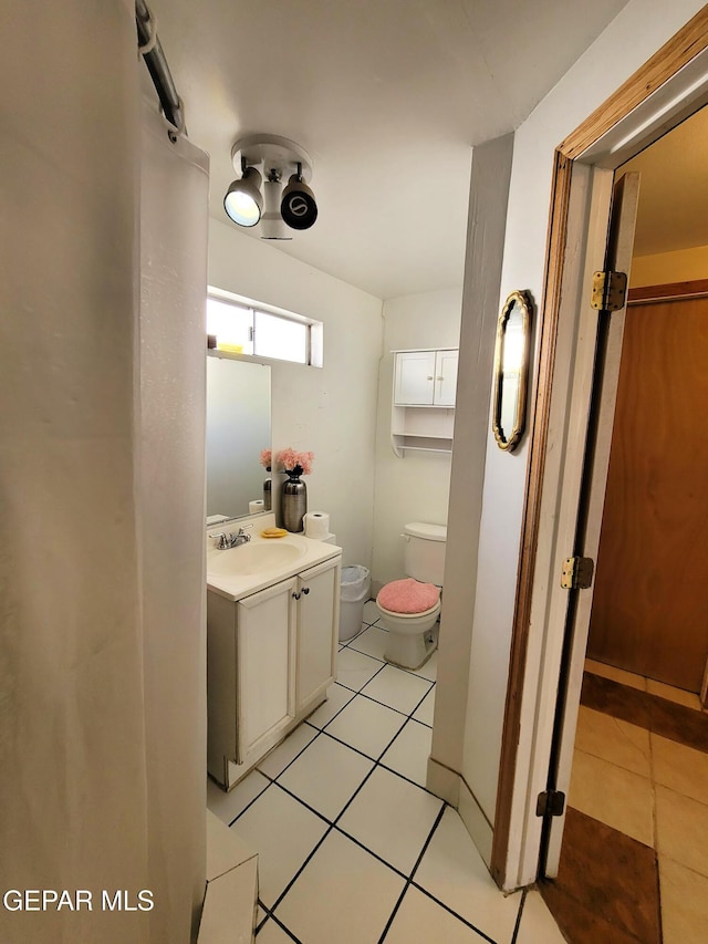 bathroom with tile patterned flooring, vanity, and toilet