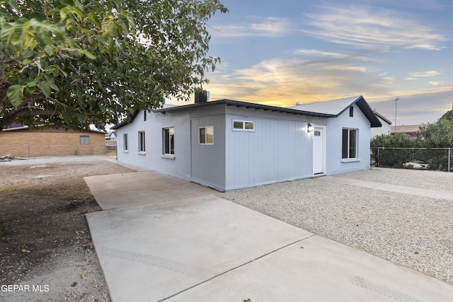 property exterior at dusk with a patio area