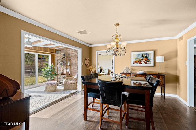 dining area featuring crown molding, wood-type flooring, and a chandelier