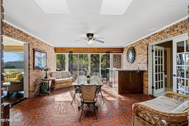 sunroom featuring plenty of natural light, ceiling fan, and a skylight