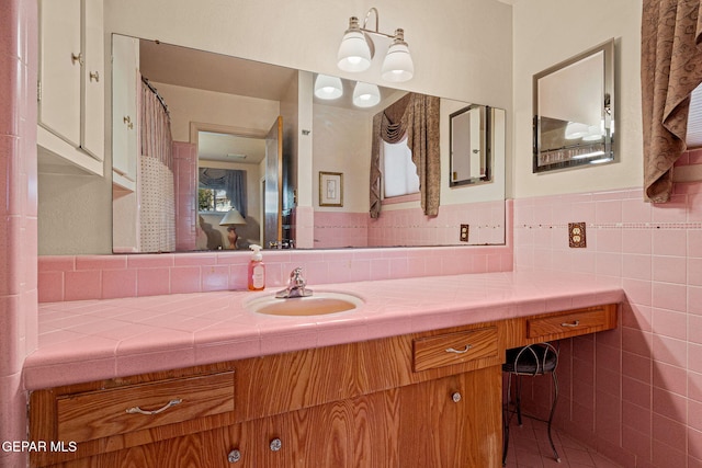 bathroom with vanity and tile walls