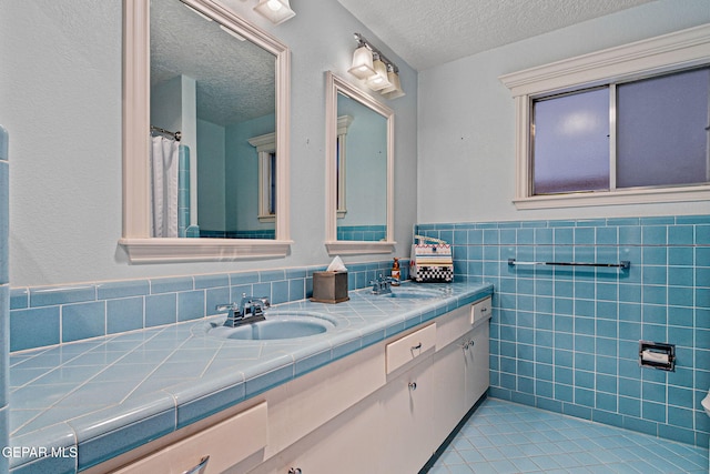 bathroom with vanity, tile walls, and a textured ceiling