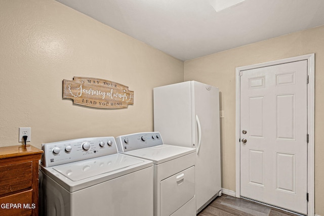 laundry room featuring cabinets, washing machine and dryer, and hardwood / wood-style floors