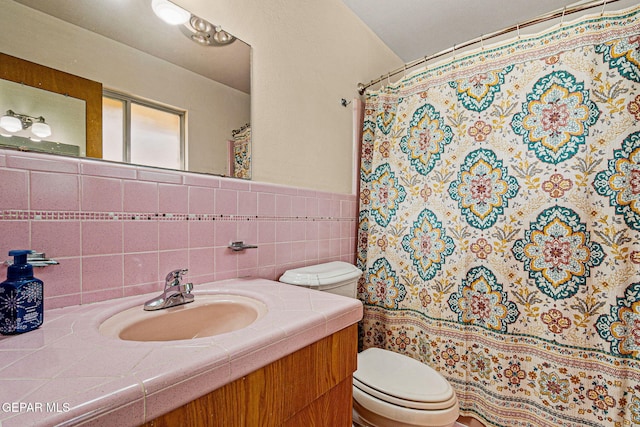 bathroom featuring vanity, tile walls, and toilet