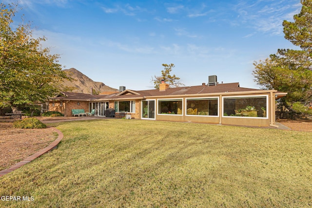 rear view of property with a patio and a lawn