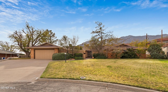 ranch-style house featuring a garage, a mountain view, and a front yard