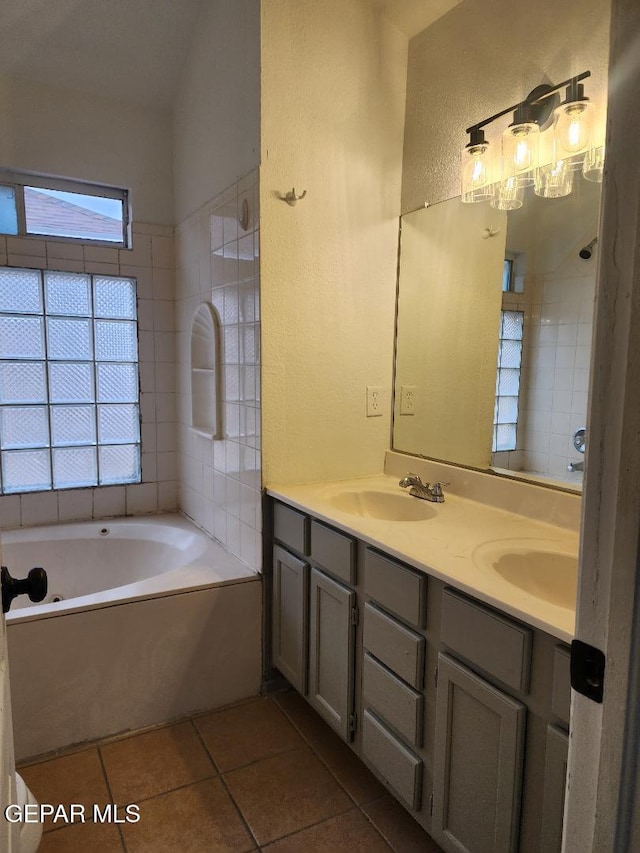 bathroom with a bath, vanity, and tile patterned floors