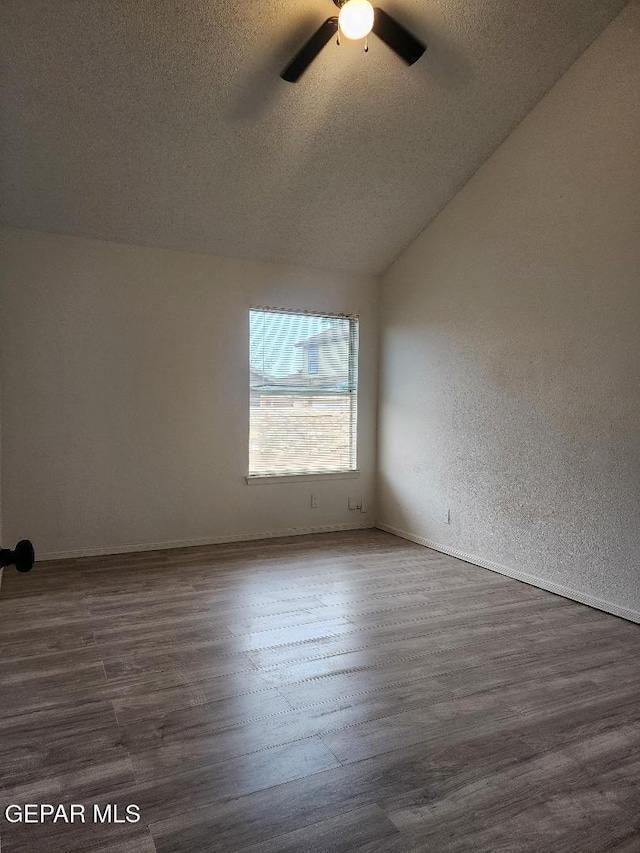 unfurnished room with a textured ceiling, ceiling fan, dark hardwood / wood-style floors, and lofted ceiling