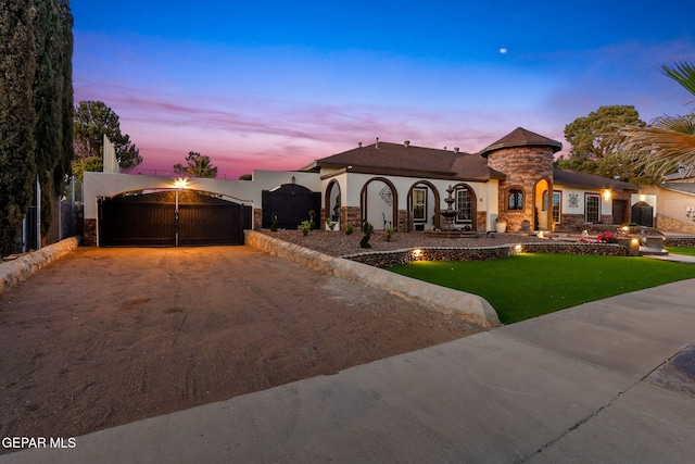 11179 Leo Collins Dr, El Paso, TX 79936 - view of front facade with stucco siding, stone siding, dirt driveway, a gate, and a lawn