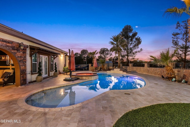 11179 Leo Collins Dr, El Paso, TX 79936 - pool at dusk featuring an in-ground hot tub, french doors, a patio area, and a fenced backyard