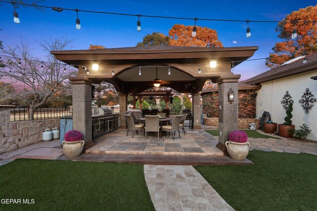 11179 Leo Collins Dr, El Paso, TX 79936 - patio terrace at dusk with a gazebo, exterior kitchen, and a patio