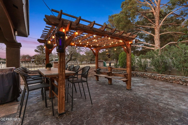 11179 Leo Collins Dr, El Paso, TX 79936 - patio terrace at dusk featuring a pergola, outdoor dining area, and a patio