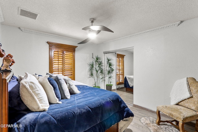 11179 Leo Collins Dr, El Paso, TX 79936 - bedroom featuring a textured ceiling, light wood finished floors, a ceiling fan, and a closet