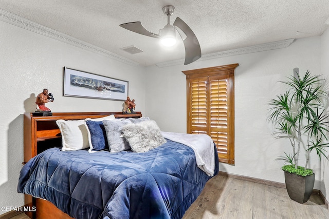 11179 Leo Collins Dr, El Paso, TX 79936 - bedroom with wood finished floors, a textured ceiling, and a ceiling fan