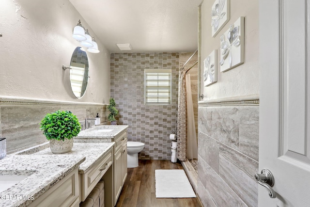 11179 Leo Collins Dr, El Paso, TX 79936 - full bath with tile walls, vanity, tiled shower, and wood finished floors
