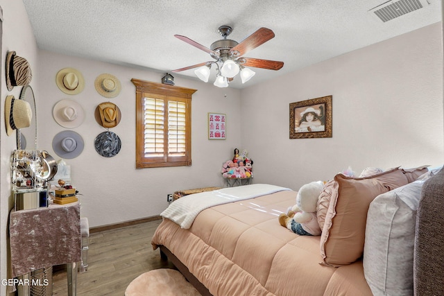 11179 Leo Collins Dr, El Paso, TX 79936 - bedroom with wood finished floors, a textured ceiling, and a ceiling fan