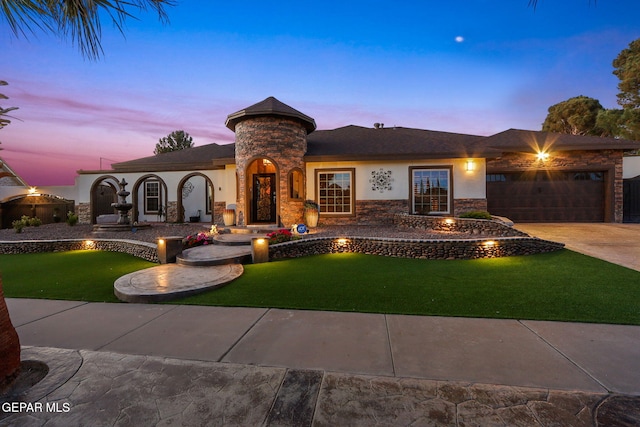 11179 Leo Collins Dr, El Paso, TX 79936 - view of front facade with stone siding, an attached garage, stucco siding, a yard, and concrete driveway