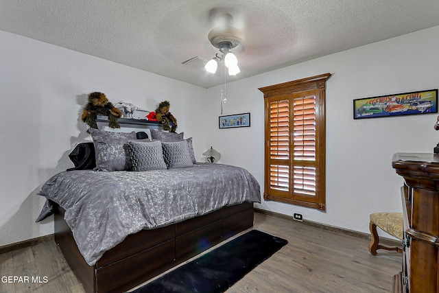 11179 Leo Collins Dr, El Paso, TX 79936 - bedroom with wood finished floors, baseboards, a textured ceiling, and ceiling fan