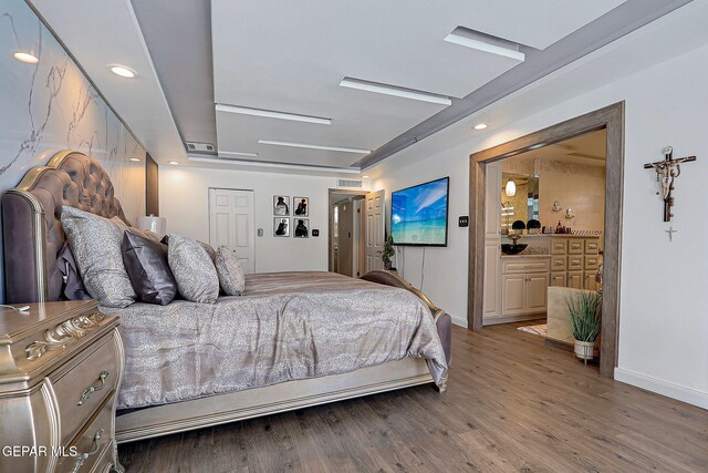 11179 Leo Collins Dr, El Paso, TX 79936 - bedroom featuring baseboards, wood finished floors, and connected bathroom