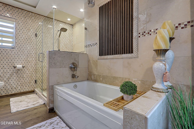 11179 Leo Collins Dr, El Paso, TX 79936 - full bath with wood finished floors, a stall shower, a garden tub, toilet, and tile walls