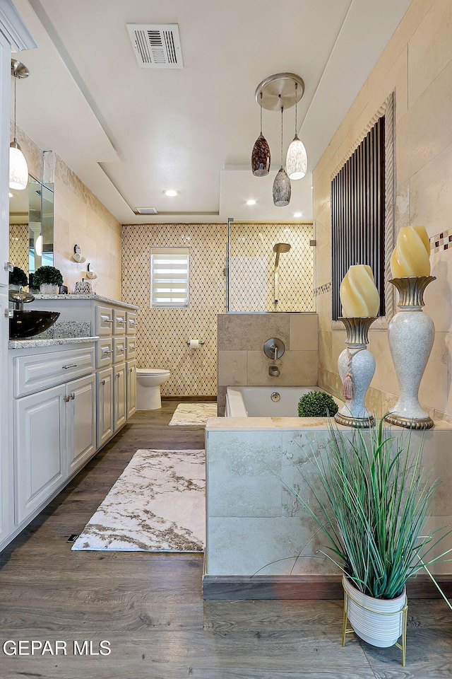 11179 Leo Collins Dr, El Paso, TX 79936 - bathroom with vanity, tile walls, toilet, a walk in shower, and wood finished floors