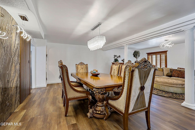 11179 Leo Collins Dr, El Paso, TX 79936 - dining space featuring decorative columns, wood finished floors, a chandelier, and baseboards