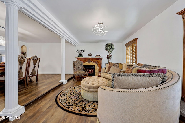 11179 Leo Collins Dr, El Paso, TX 79936 - living area with ornate columns, wood finished floors, and a lit fireplace