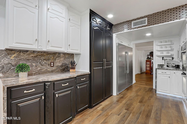 11179 Leo Collins Dr, El Paso, TX 79936 - kitchen with built in fridge, white cabinets, wood finished floors, open shelves, and recessed lighting