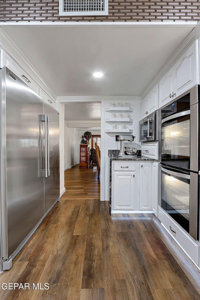 11179 Leo Collins Dr, El Paso, TX 79936 - kitchen featuring appliances with stainless steel finishes, white cabinets, dark wood-style floors, dark countertops, and crown molding