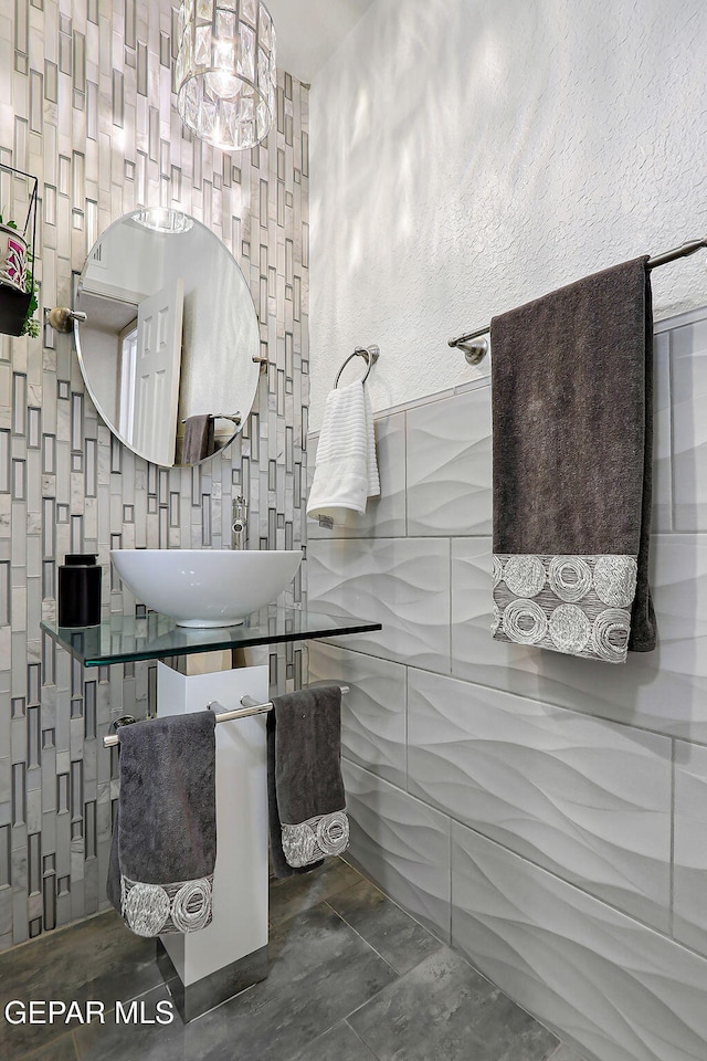 11179 Leo Collins Dr, El Paso, TX 79936 - bathroom featuring tile walls, a sink, and a textured wall
