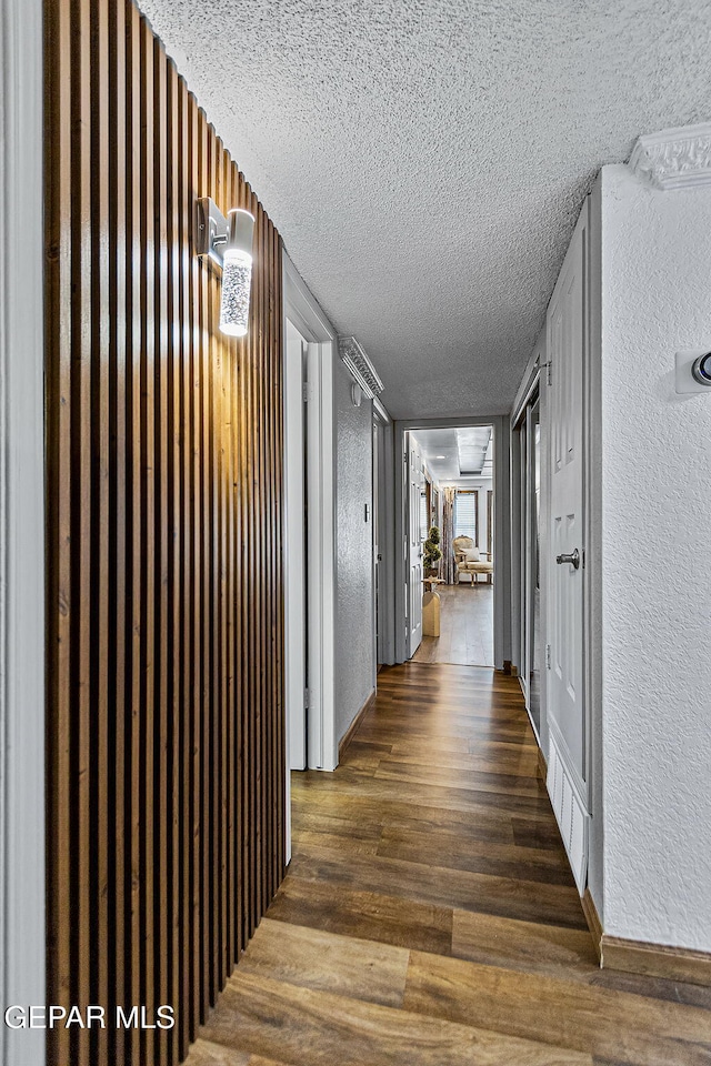 11179 Leo Collins Dr, El Paso, TX 79936 - hall with a textured ceiling, a textured wall, and wood finished floors