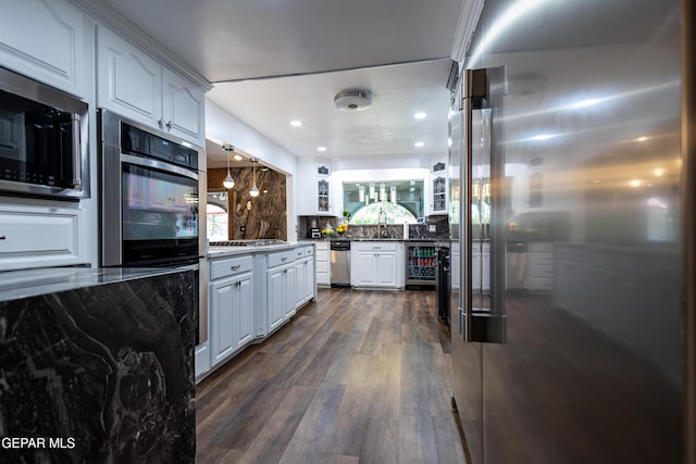 11179 Leo Collins Dr, El Paso, TX 79936 - kitchen with appliances with stainless steel finishes, white cabinetry, decorative backsplash, dark wood-style flooring, and beverage cooler