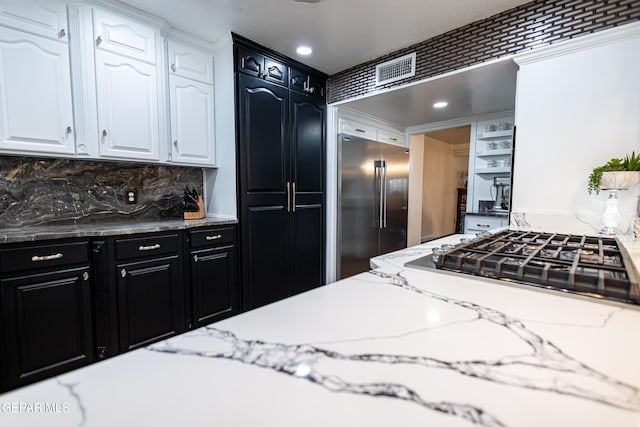 11179 Leo Collins Dr, El Paso, TX 79936 - kitchen featuring appliances with stainless steel finishes, white cabinetry, dark cabinetry, decorative backsplash, and recessed lighting