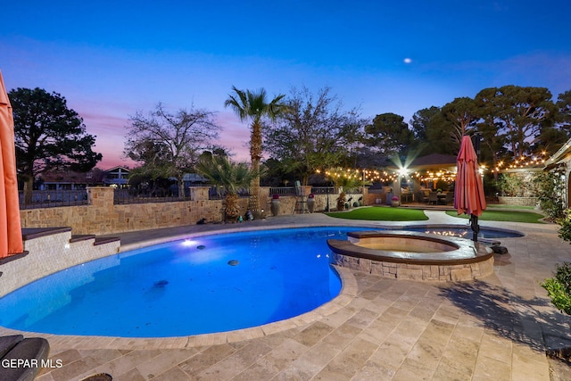 11179 Leo Collins Dr, El Paso, TX 79936 - pool at dusk featuring a patio, a fenced backyard, and a pool with connected hot tub