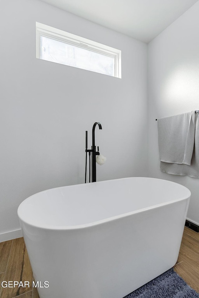 bathroom with hardwood / wood-style floors and a bathtub